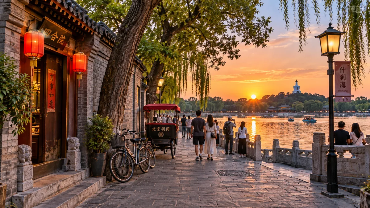 A hutong lane opening onto the Houhai lake at dusk, with grey-brick courtyard walls, bicycles and locals strolling