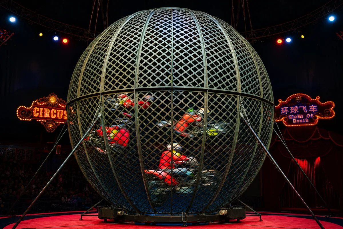 Motorcycles racing inside a spherical steel mesh cage during the ERA acrobatic show in Shanghai