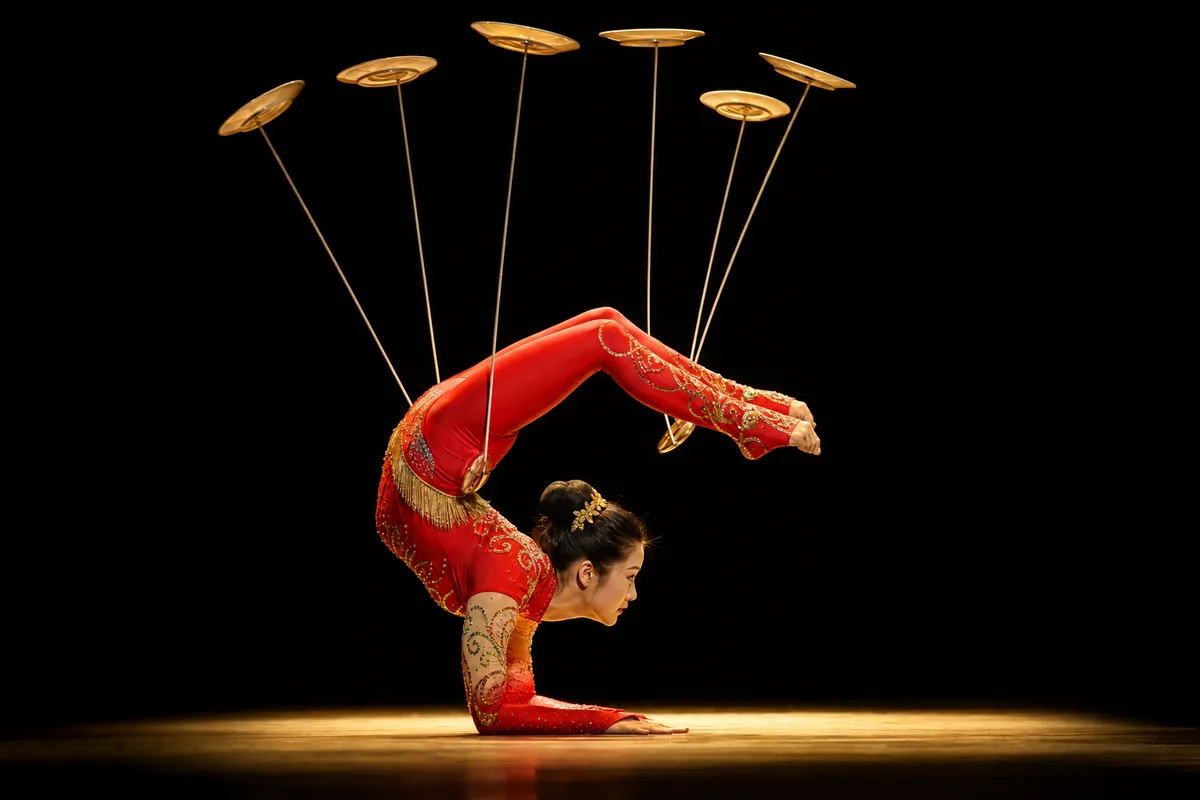 Female Chinese acrobat performing a contortion and plate-spinning balancing act on stage