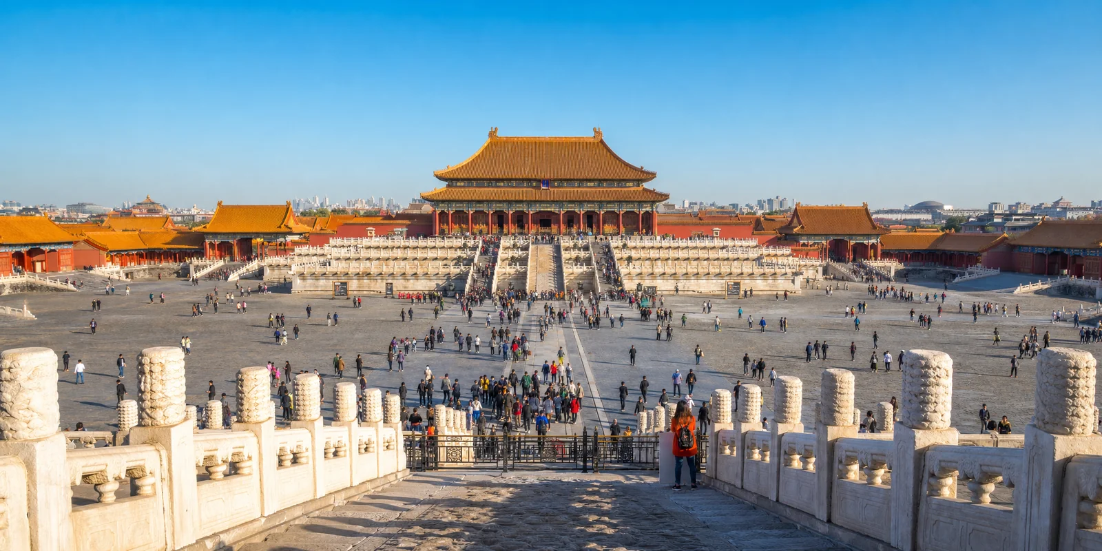 Golden roofs of the Forbidden City palace halls under a clear blue Beijing sky