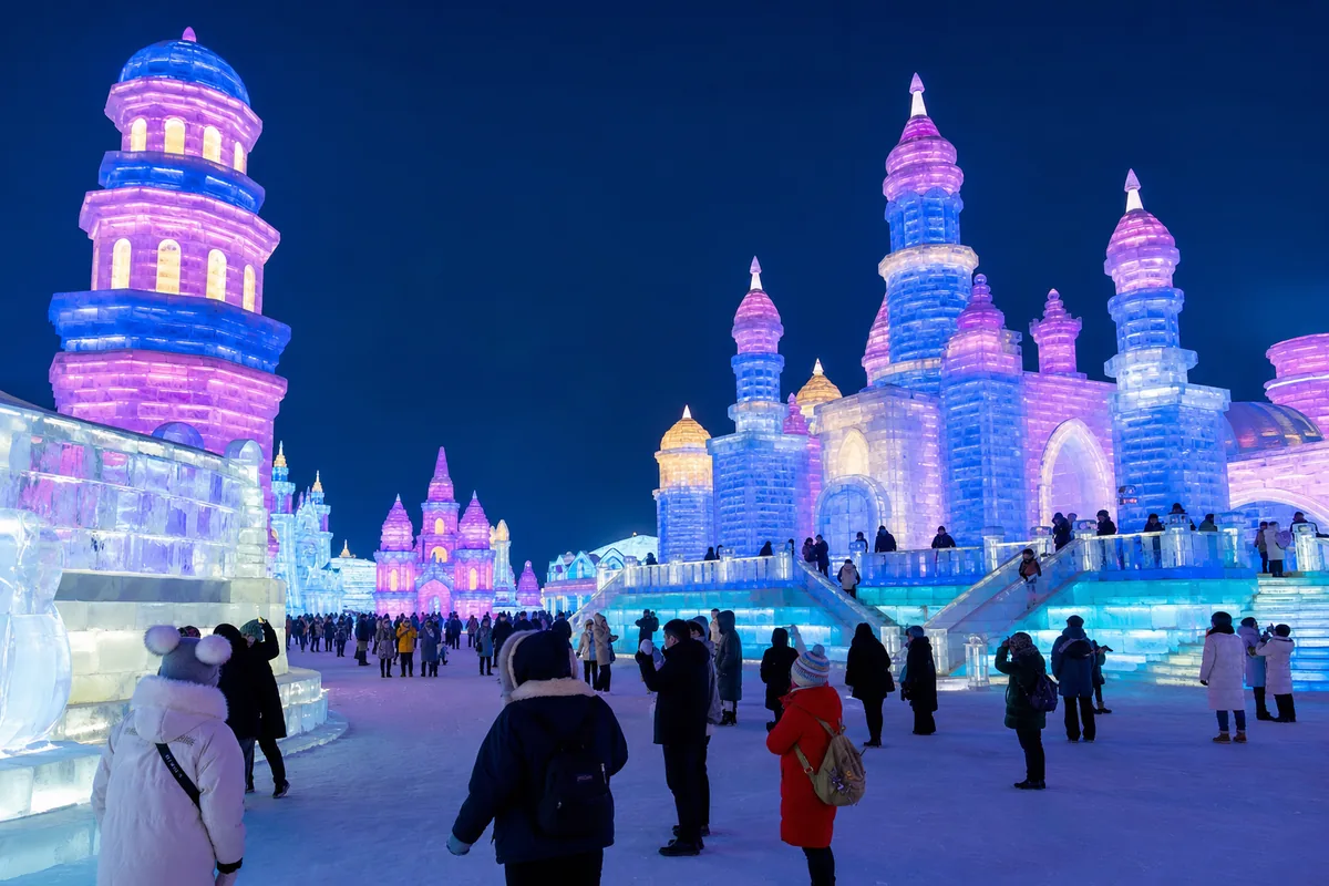 Illuminated ice sculptures at night during the Harbin Ice and Snow Festival