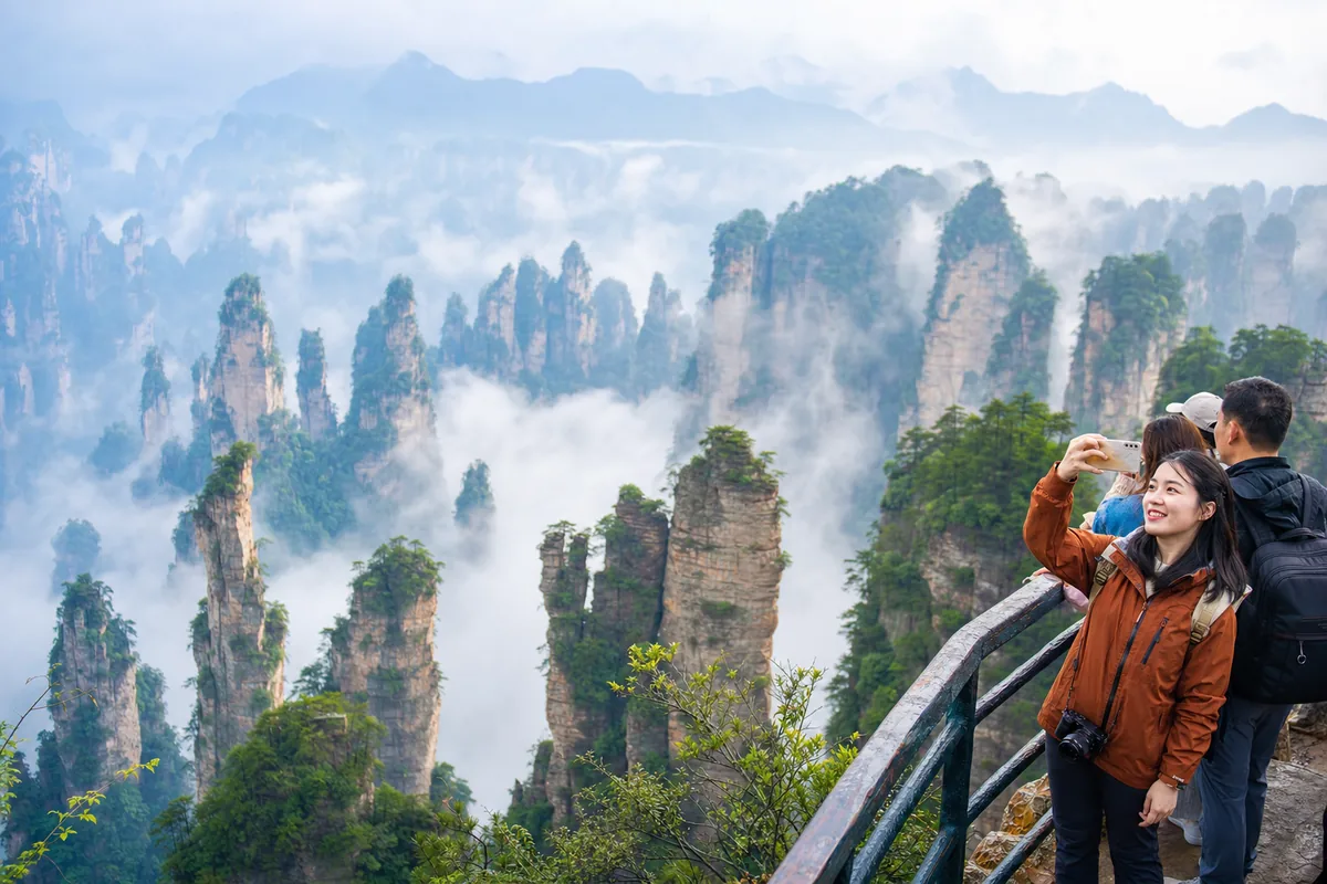 Sandstone pillar peaks of Zhangjiajie National Forest Park rising through mist
