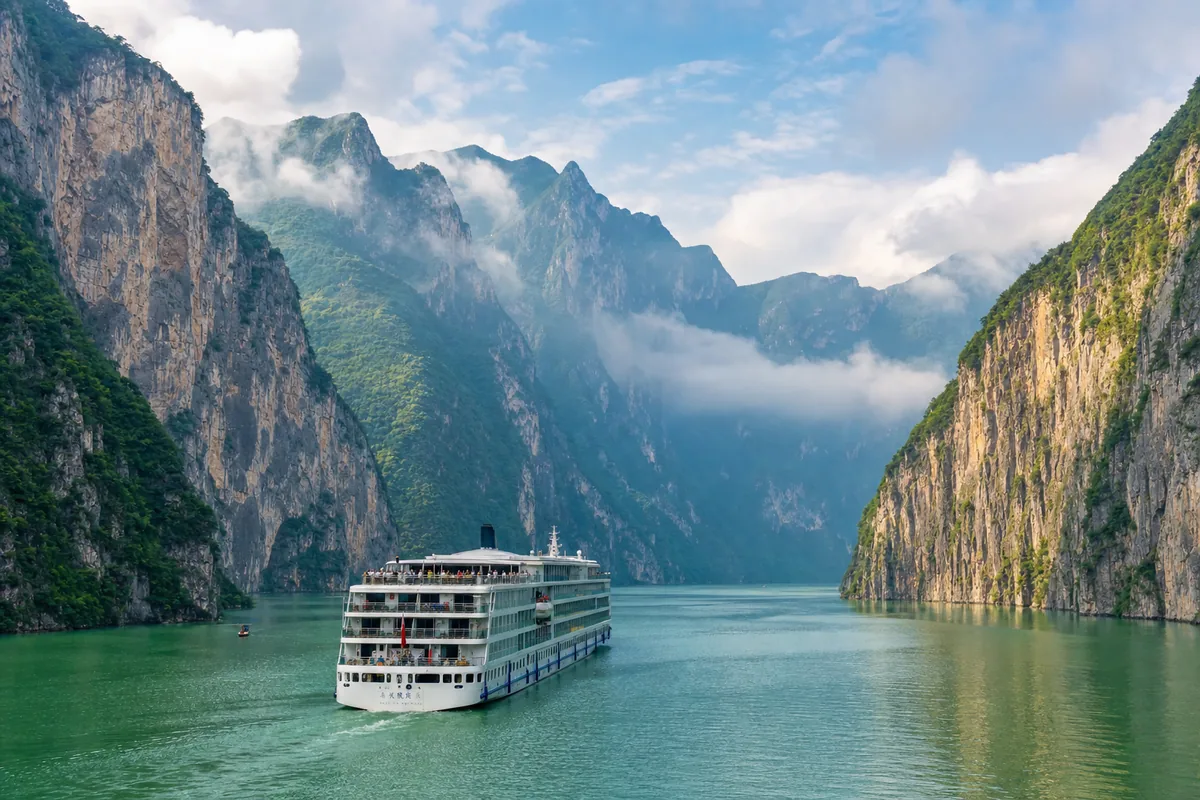 Cruise ship sailing through the steep cliffs of the Yangtze River Three Gorges near Chongqing