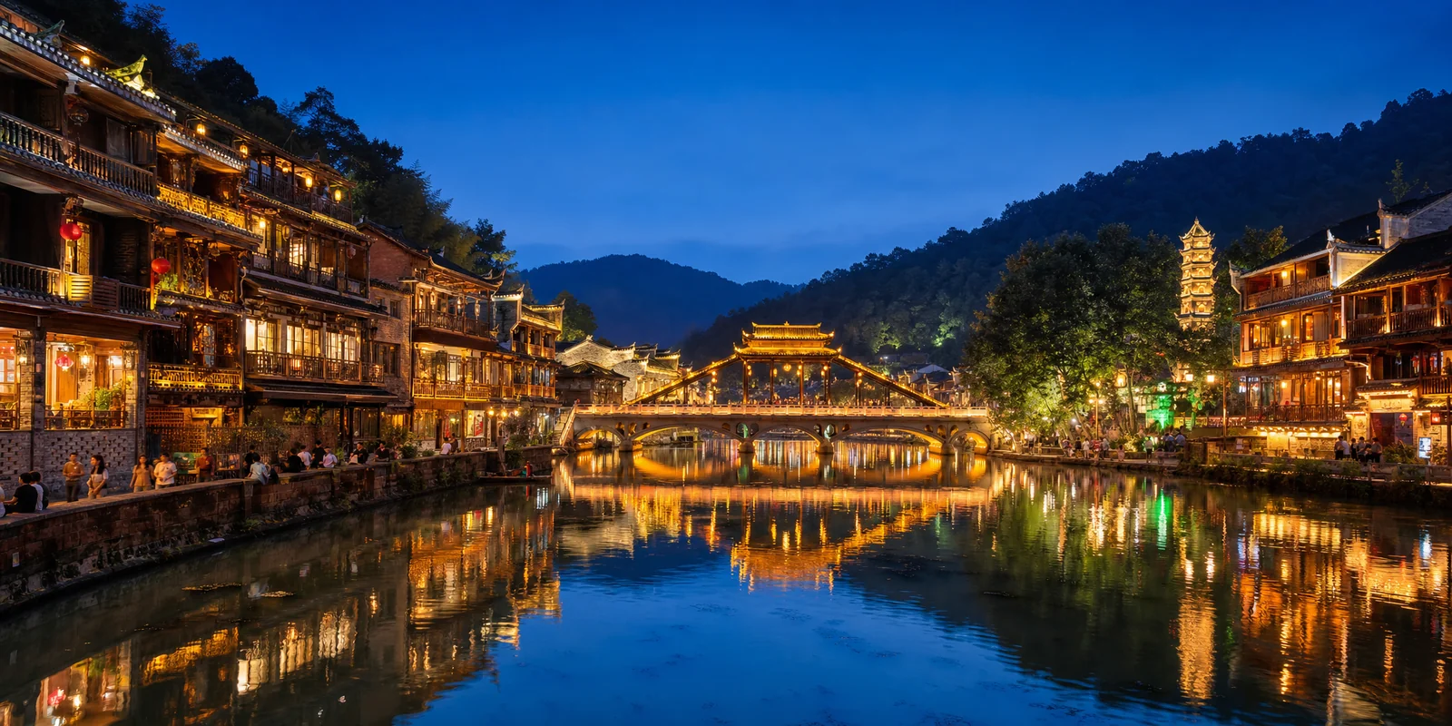 Fenghuang Ancient Town at night with lit stilt houses reflected in the Tuojiang River
