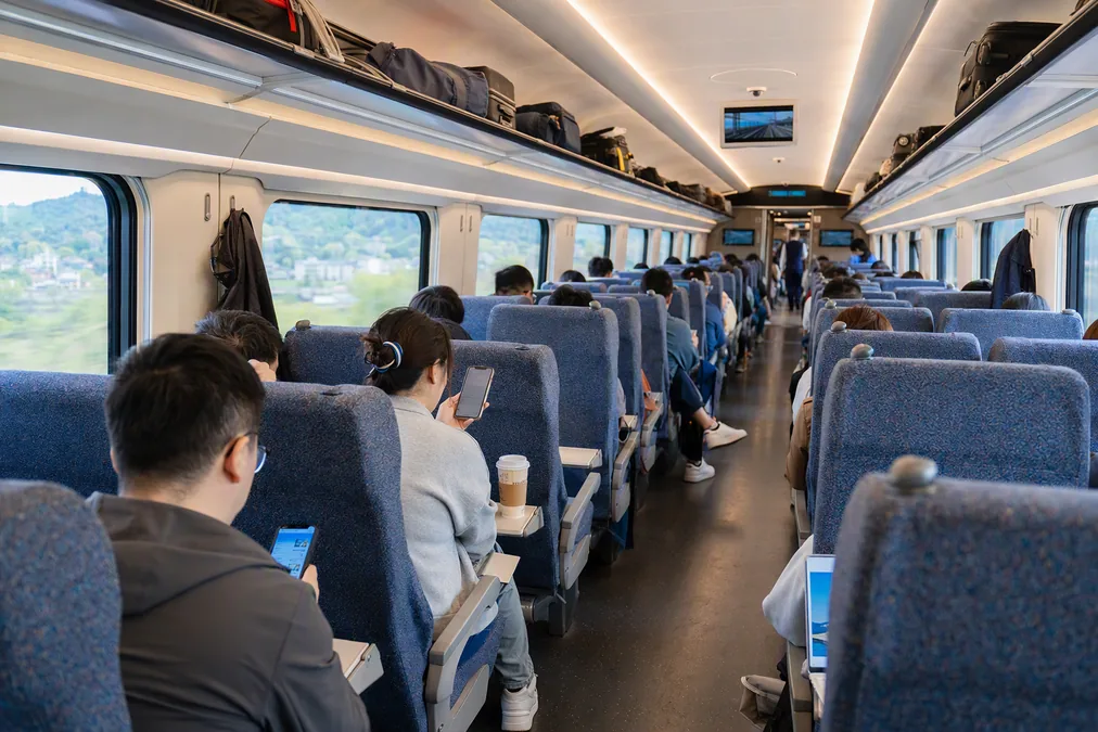 Inside a second-class coach on a Chinese high-speed train, bright seats in rows with a few passengers