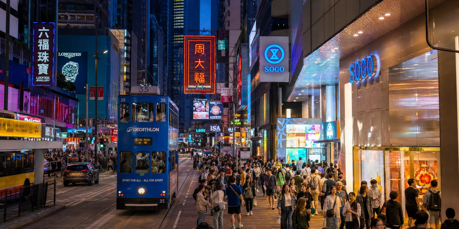 Busy Hong Kong shopping street at night with neon signs and mall storefronts