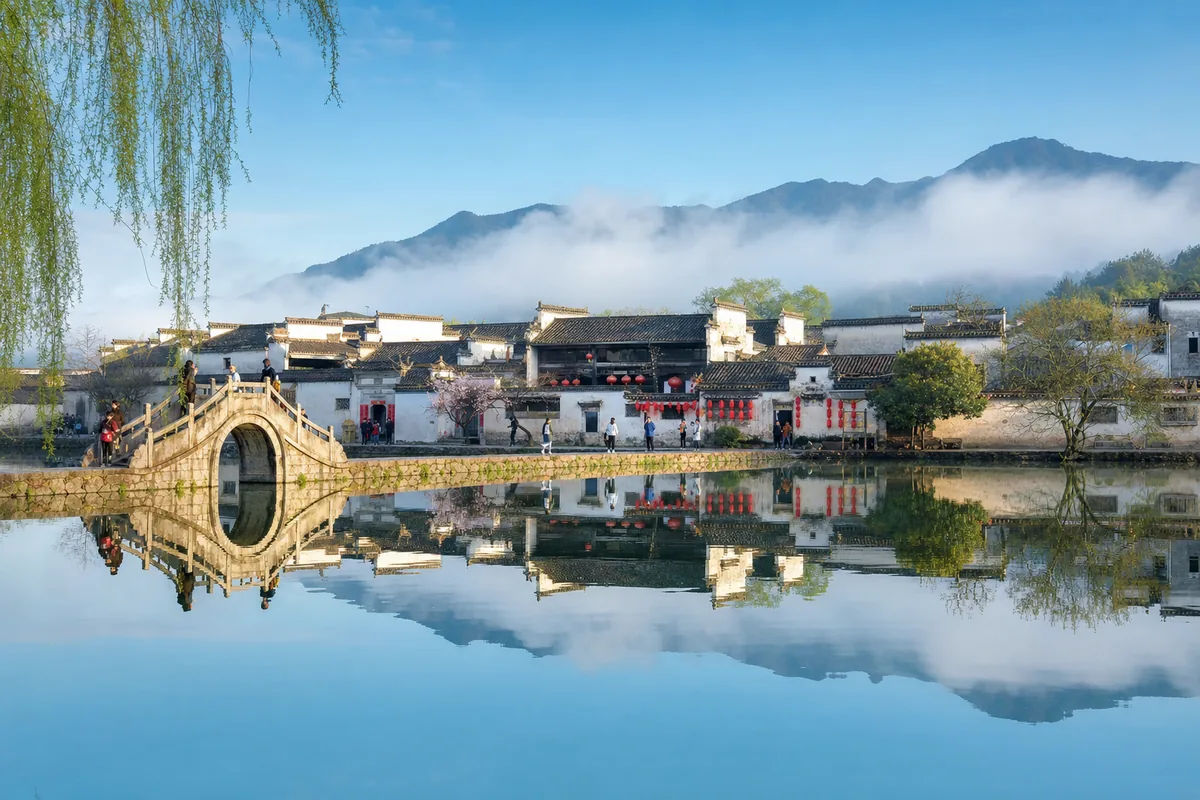 Reflections of white-walled Huizhou houses in the still water at Hongcun village