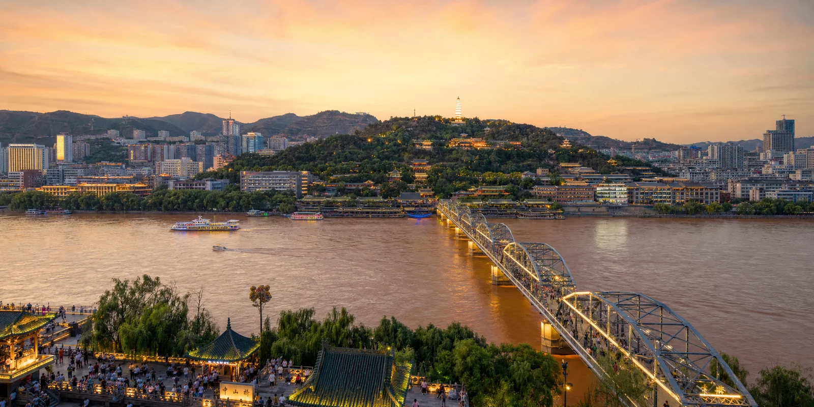 Zhongshan Bridge over the Yellow River in Lanzhou at dusk with White Pagoda Hill behind