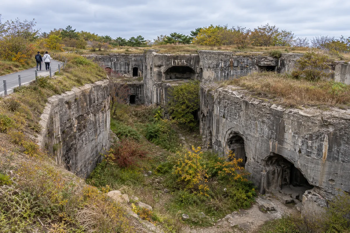 Broken concrete walls and a trench at the Dongjiguanshan North Fort in Lushun