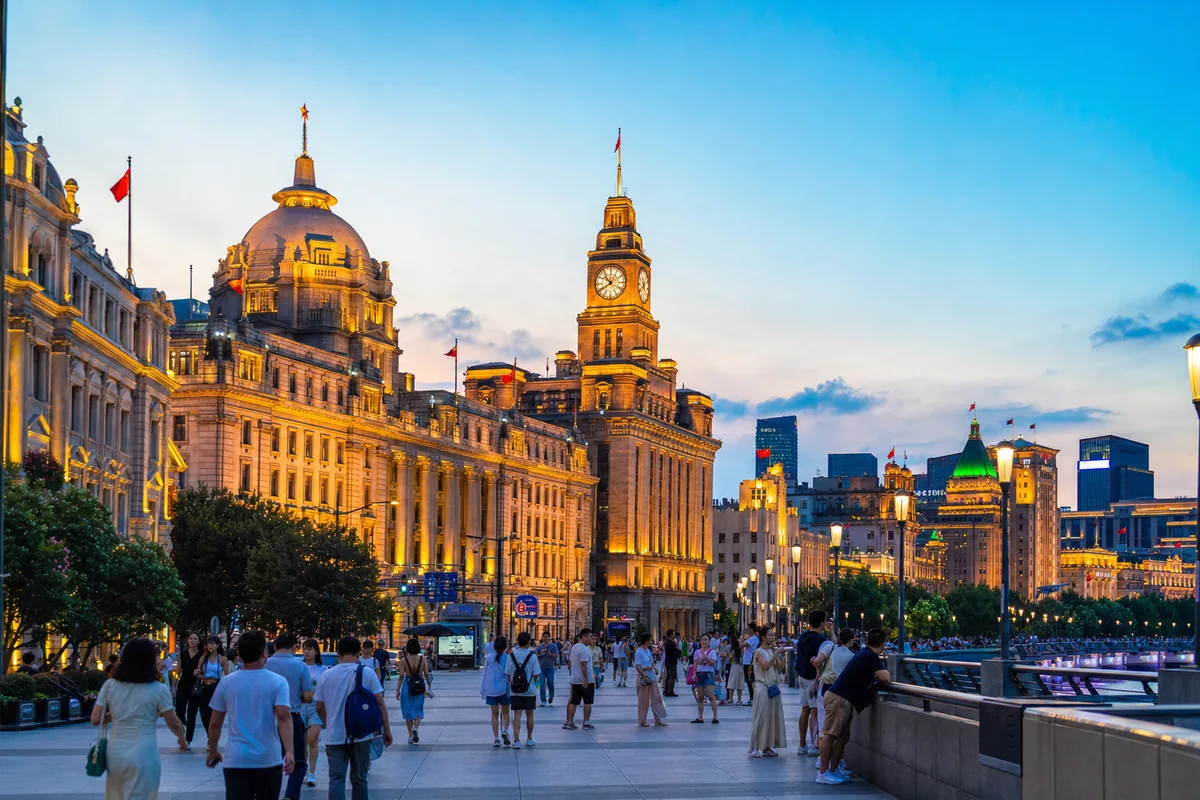 Row of historic European-style buildings along the Bund promenade in Shanghai at dusk