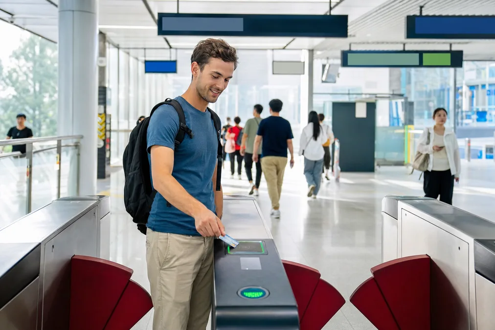 A traveler tapping a contactless bank card on a Shanghai metro fare gate