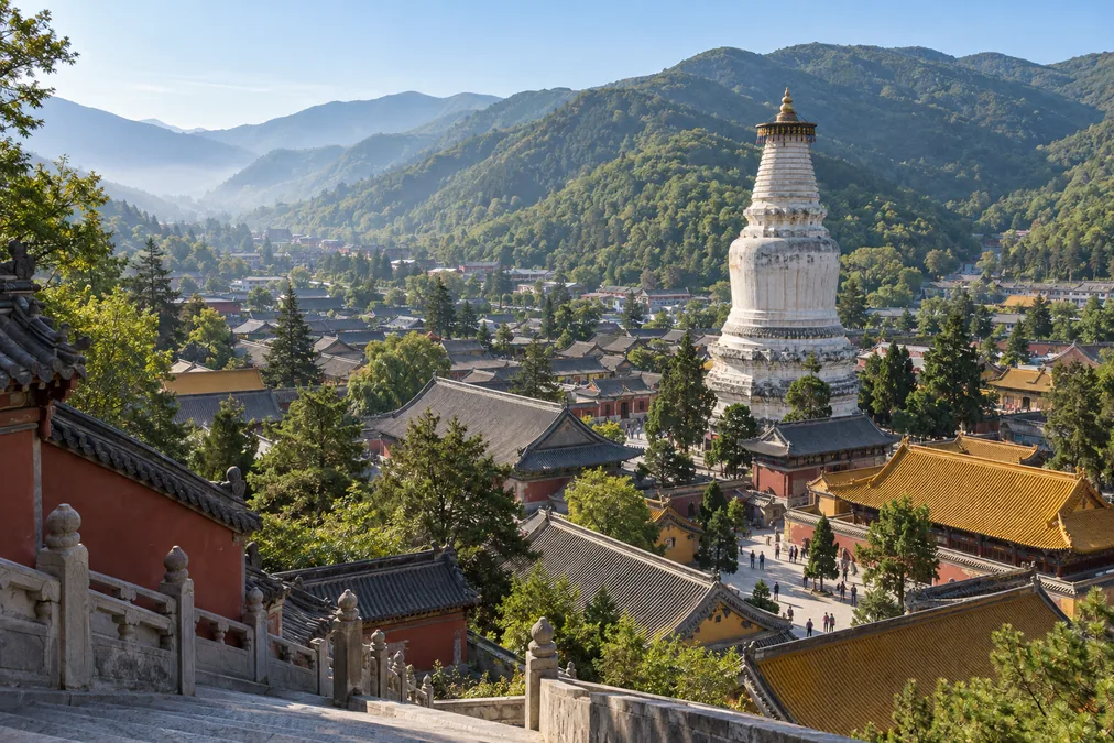 The white pagoda of Tayuan Temple rising above temple roofs in the Taihuai valley at Mount Wutai