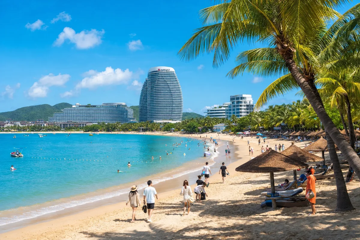 Sanya beach resort scene with palm trees, turquoise bay and resort hotels in summer