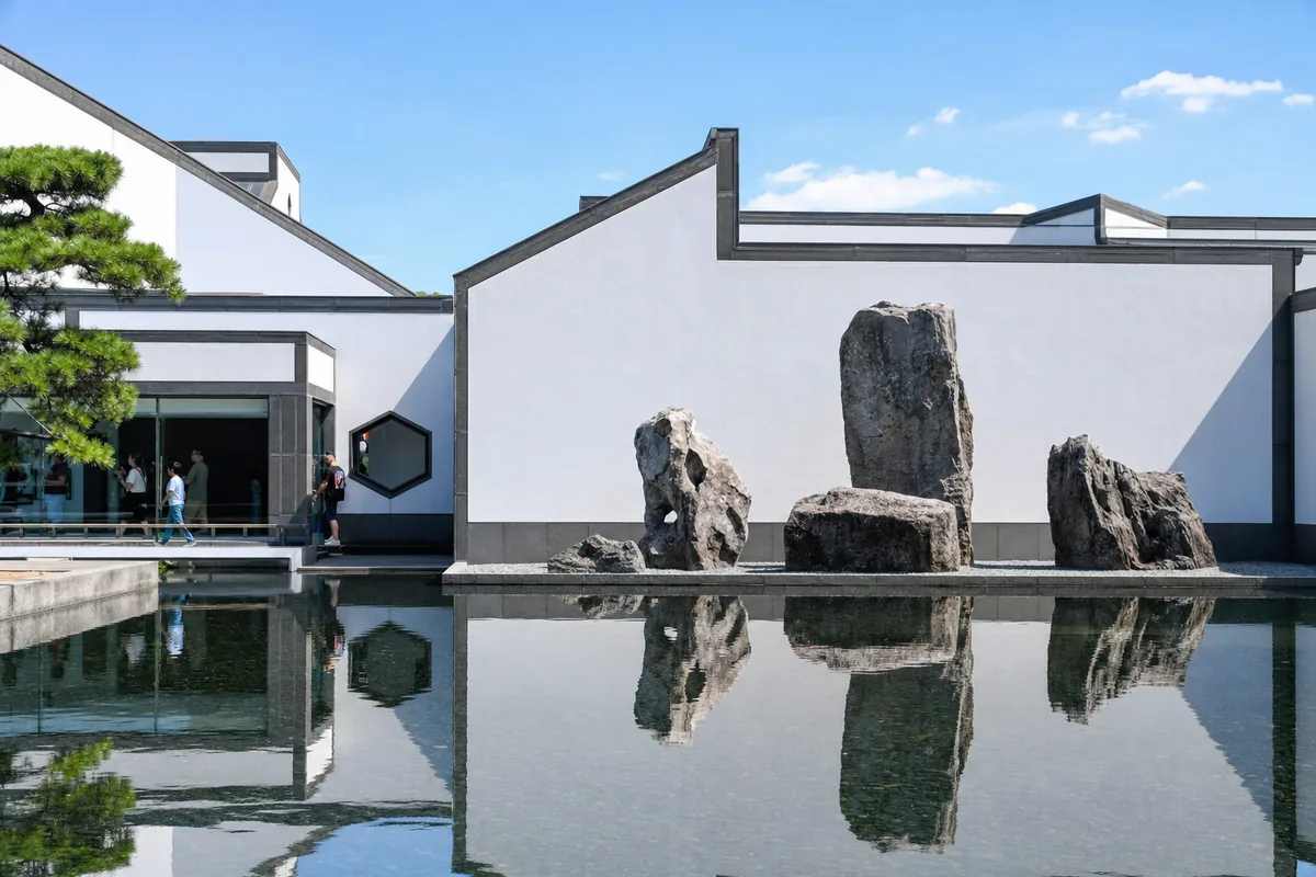 The modern geometric architecture of Suzhou Museum designed by I. M. Pei with white walls and a reflecting pool