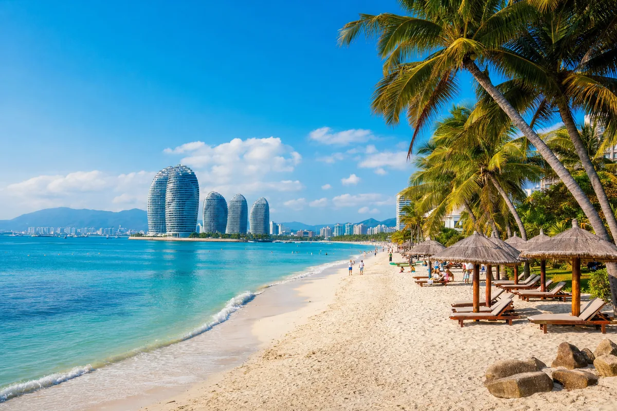 Sunny winter beach scene at Yalong Bay in Sanya, Hainan, with palm trees, white sand and turquoise sea