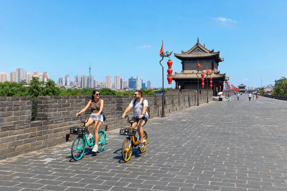 Travelers cycling along the broad top of Xi'an's ancient city wall between the battlements