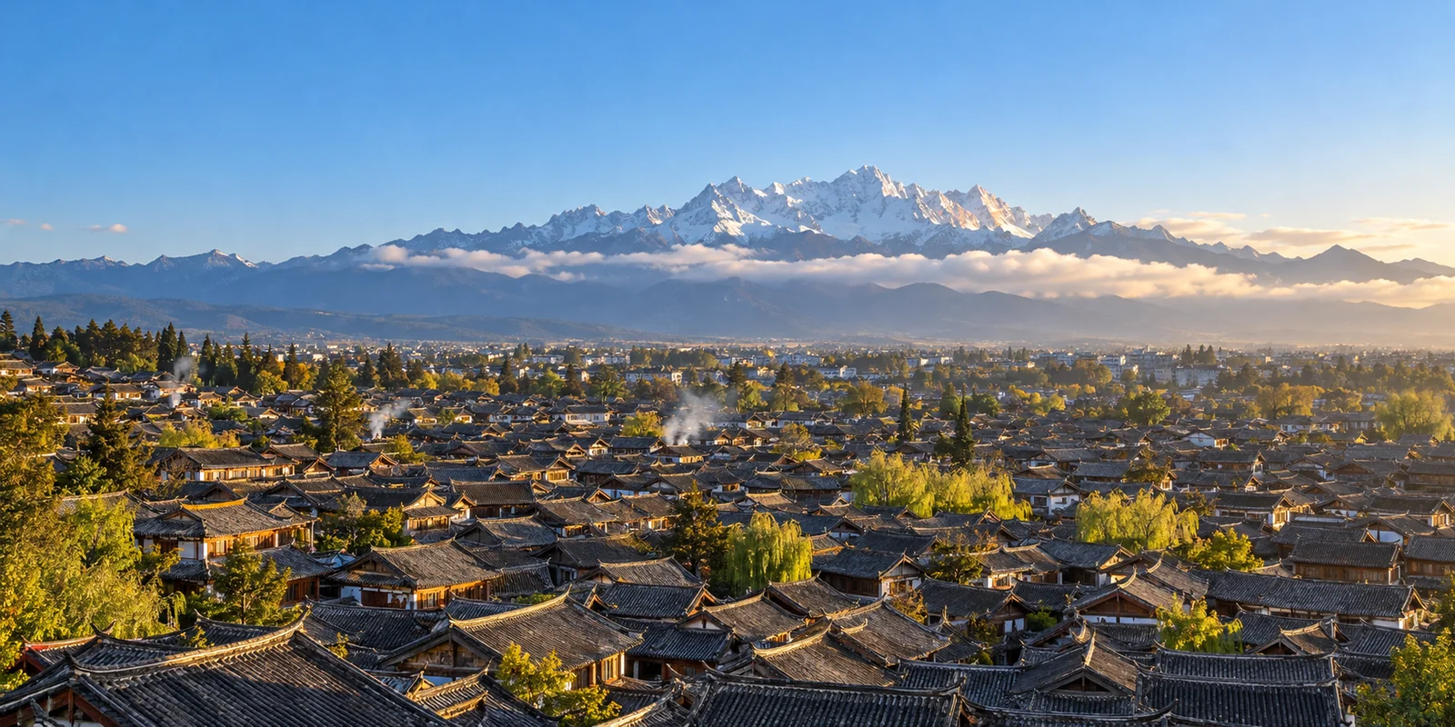 Grey tiled roofs of Lijiang Old Town in the morning, with the snow-capped peaks of Jade Dragon Snow Mountain on the horizon