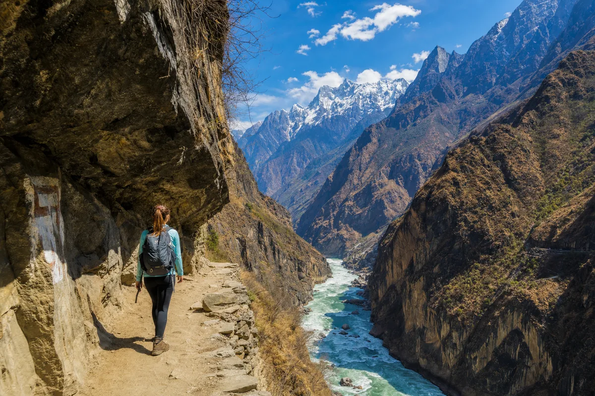 Hiking the High Trail of Tiger Leaping Gorge above the Jinsha River with snow peaks beyond